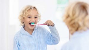 Bambino lava i denti con il dentifricio